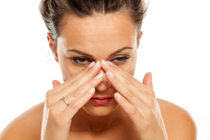 a young woman has pain in the sinuses a young woman has pain in the sinuses